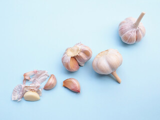 Top view of garlic and peeled cloves isolated on blue background.