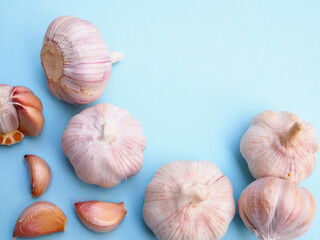 Top view of garlic and peeled cloves isolated on blue background