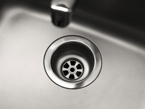 Close-up Of A Drain In A Steel Sink. Clean Sink, No Blockages. Water Supply.