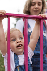 Fototapeta premium mom and her son walk in the park in identical denim jumpsuits. they enjoy time together and love each other. High quality photo