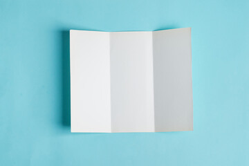 Minimal trifold brochure template above blue background with shadows