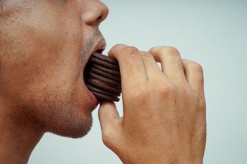 close up of man eating many chocolate biscuits
