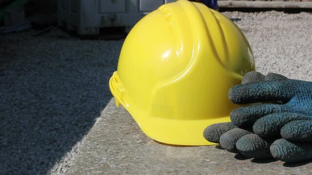Yellow hard hat helmet with gloves on a construction or building site. Tracking Shot. Stock Video Clip Footage