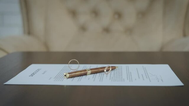 Divorce decree with rings. Wedding rings swirl on divorce papers.