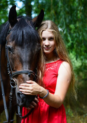 Fototapeta premium outdoor portrait of young beautiful woman with horse. Against the background of a tree