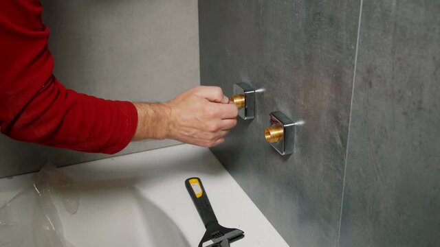 Man installs shower system in the bathroom.