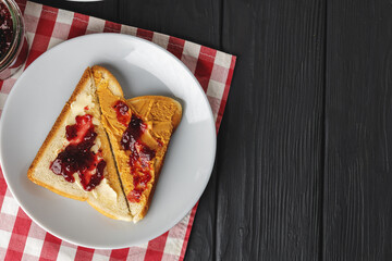 Toasted bread slices with berry jam on wooden table