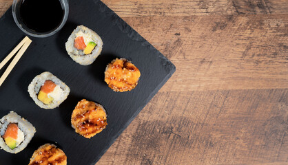 Sushi roll set on the black plate. Japanese food. Top view.