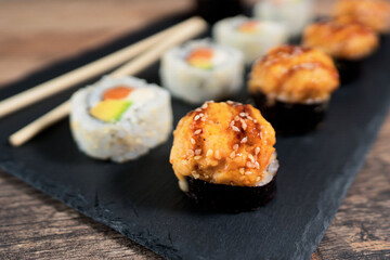 Sushi roll set on the black plate. Japanese food.