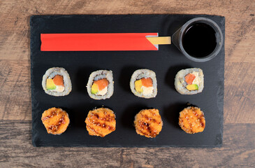Sushi roll set on the black plate. Japanese food. Top view.