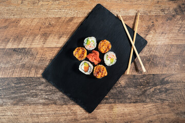 Fototapeta na wymiar Sushi roll set on the black plate. Japanese food.