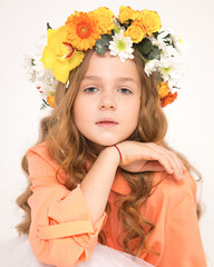 Studio photo of a beautiful long-haired red-haired girl with chic curls, white background. A forest nymph with a flower accessory on head. Advertising barbershop products in social networks or website