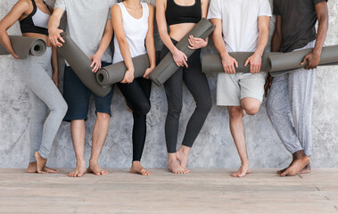 Fototapeta na wymiar Wellness Concept. Sporty People With Yoga Mats Standing Near Gray Wall