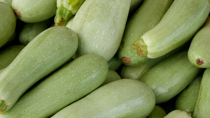 A lot of fresh zucchini in a box close-up at the agricultural market