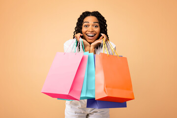 Excited Shopaholic Woman Holding Shopping Bags On Beige Studio Background