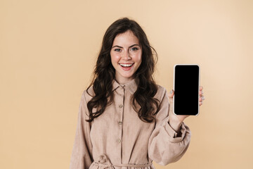 Image of cheerful attractive woman smiling and showing cellphone