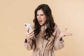 Image of angry attractive woman screaming and using cellphone
