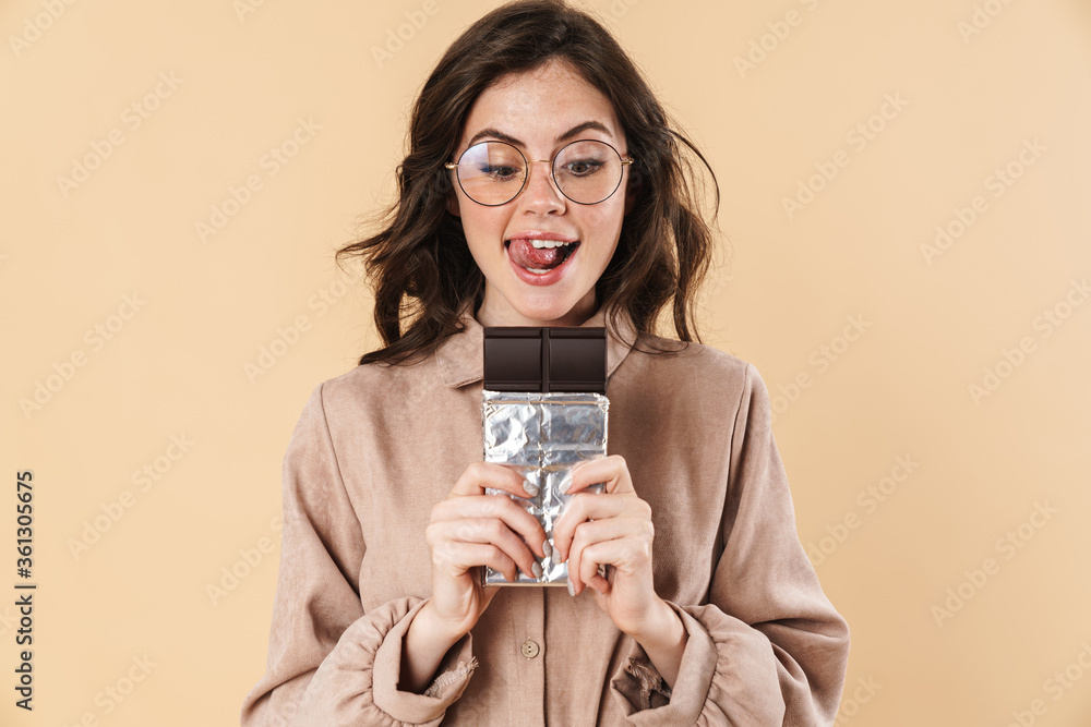 Poster Image of excited caucasian woman in eyeglasses posing with chocolate