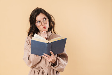 Image of thinking caucasian woman in eyeglasses reading book