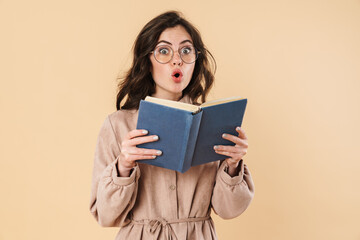 Image of surprised caucasian woman in eyeglasses reading book