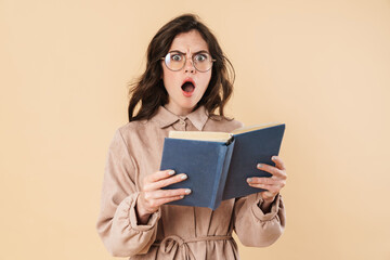Image of shocked caucasian woman in eyeglasses reading book