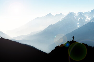 Spectacular mountain ranges silhouettes. Man reaching summit enjoying freedom. View from Top of...
