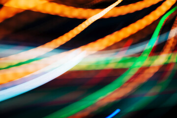 Colorful pattern of orange, green and red dynamic lines of light. Modern blurred background. Art concept of lighting effects.