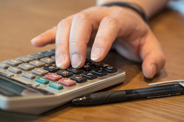 Man's finger press on plus button calculator.