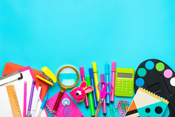 Frame from school and office supplies Paper clips, scissors, pens, felt-tip pens, sharpener, calculator, stapler isolated on blue background Flat lay Top view Back to school, education concept Mock up