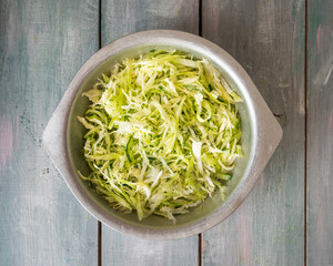 Salad of fresh vegetables, white cabbage and cucumbers in an aluminum plate