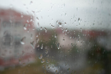 city ​​view through a window with raindrops