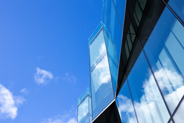 Modern architecture business office building or business center with glass facade, looking up skyscraper. Glass facade with blue sky reflection. Downtown. Concepts of financial, economics, future