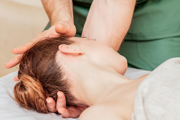 Obraz na płótnie Canvas Head massage of woman by hands of massage therapist close up.