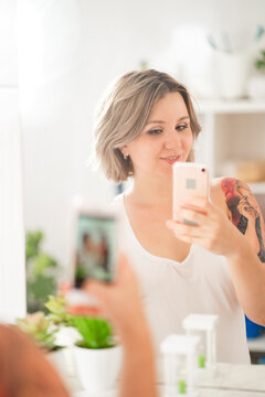 sexy girl with tattoos taking selfie photo on phone in bathroom mirror.