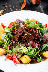 Warm salad in ginger sauce with beef and potatoes