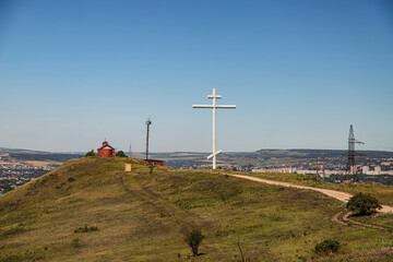 Fototapeta na wymiar A large metal cross of worship stands on a hill at the site of the founding of the Cossack village