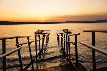 Fototapeta na wymiar Bridge of a lake with mountains in a sunset