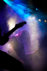 Fototapeta na wymiar Metal musician in the fogged stage