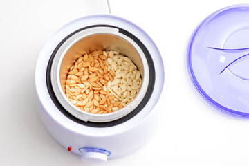 Electric wax warmer or wax heater with wax drops inside while heating the wax