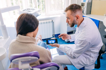 dentistry and healthcare concept. dentist with phone showing tee © Ivan