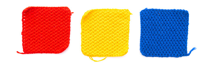 Three knitted patch squares: red, yellow, blue isolated on white background
