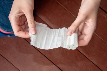 Female hands unwind with toilet paper. The concept of poverty. Top view