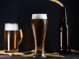 Cold light beer in a glass on a dark table.