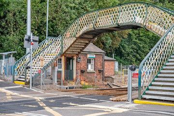 Old metal pedestrian bridge over the railway line in the Norfolk village of Brundall