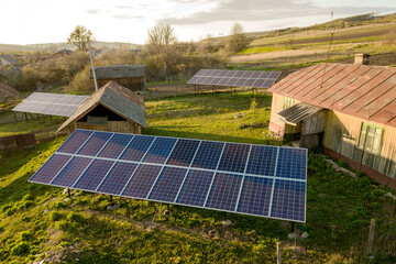 Aerial top down view of solar panels in green rural village yard.
