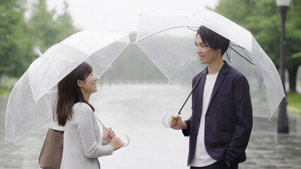 雨の日に傘を差してデートするカップル