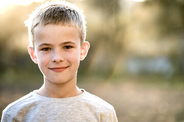 Portrait of a child boy outdoors on a warm sunny summer day. - obrazy, fototapety, plakaty