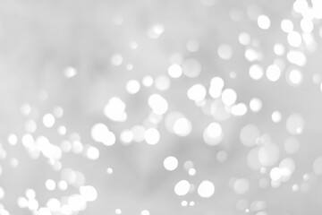 White glitter vintage lights background. White bokeh on black background.