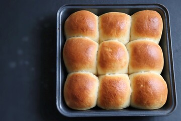 Freshly baked homemade Mumbai style golden Ladi pav or soft dinner bread roll in a baking tray....