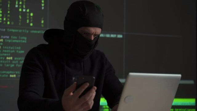 Hacker uses a mobile phone to hack the system. Stealing personal data and money from Bank accounts. The concept of cyber crime and hacking electronic devices